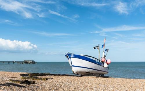 a blue and white boat sitting on the beach at Warwick Villa in Walmer