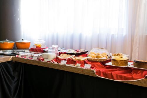 ein Tisch, der mit verschiedenen Kuchensorten und anderen Speisen gedeckt ist in der Unterkunft Hotel Vila Rica Campinas in Campinas