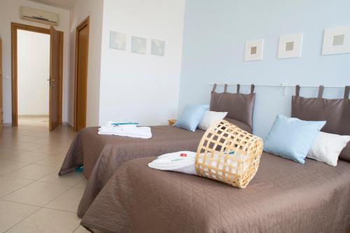 a room with two beds with a basket on top of them at L'Approdo in San Leone