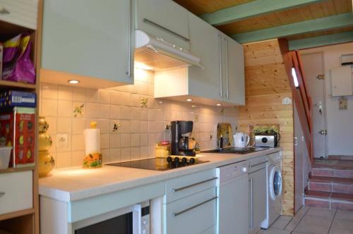 une cuisine avec des armoires blanches et un comptoir dans l'établissement SP060-019 Maison 3 pièces mezzanine SAINT PIERRE LA MER, à Saint Pierre La Mer