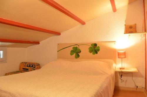 - une chambre dotée d'un lit blanc avec une plante verte sur le mur dans l'établissement SP060-019 Maison 3 pièces mezzanine SAINT PIERRE LA MER, à Saint Pierre La Mer