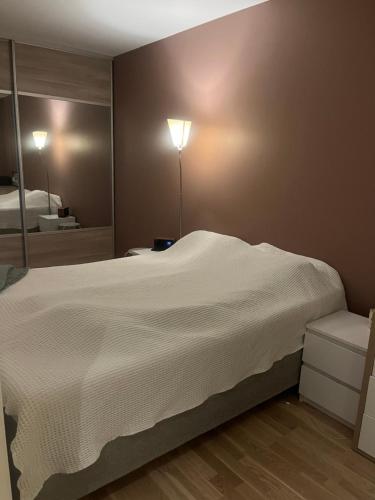 Un dormitorio con una gran cama blanca y un espejo. en Solsia Park 205, en Trondalen