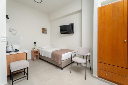 a bedroom with a bed and a table and chairs at Emi Seaside in Amoudara Herakliou