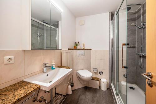 a bathroom with a sink and a toilet and a shower at Ferienwohnungen Meer-Schillig in Wangerland