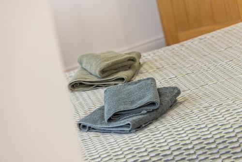 two towels sitting on top of a bed at Clondara Terrace Belfast in Belfast