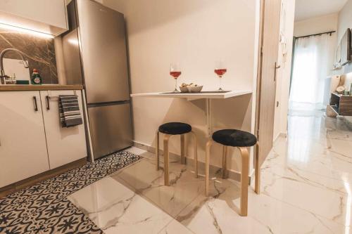a small kitchen with a bar with two stools at Victoria's Aura I in Kozani