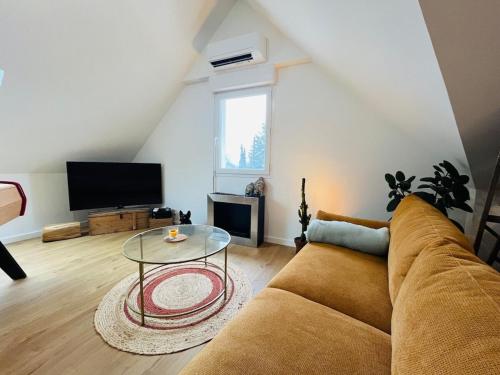 un salon avec un canapé et une table en verre dans l'établissement Casa Diderot - T3, à Angers