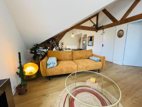 un salon avec un canapé et une table en verre dans l'établissement Casa Diderot - T3, à Angers