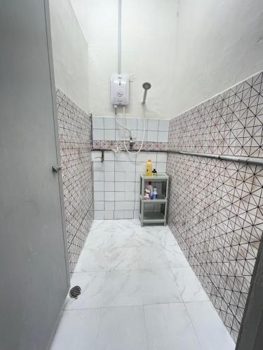 a bathroom with a white tiled wall and a shelf at Cozy95#6pax#Netflix#SukunBukitMertajam in Bukit Mertajam