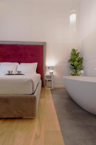 a bedroom with a large bed and a bath tub at Domus Aurea Luxury Suites in Rome