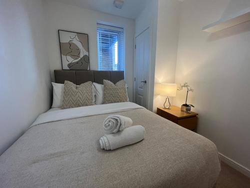 Un dormitorio con una cama con una toalla encima. en Spacious 2 Bed, 2 Bath Apartment by MCF, en Horley