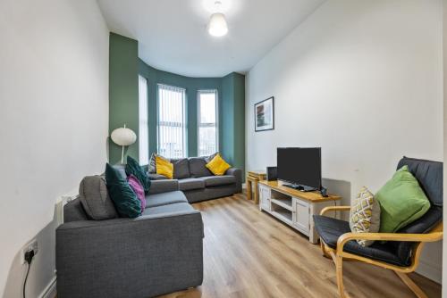 a living room with two couches and a tv at Clondara Terrace Belfast in Belfast