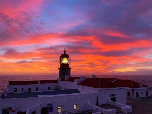 サグレスにあるStay&Relax Sagres - 3min Praia da Maretaの夕日を背景に灯台