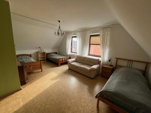 a bedroom with a bed and a couch and a chair at Haus Otto in Großhansdorf