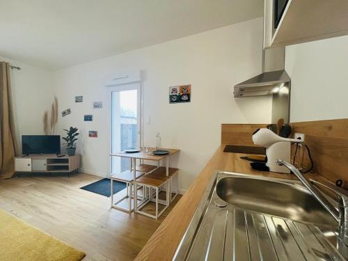 - une cuisine avec un évier et un bureau dans la chambre dans l'établissement Casa Diderot - Studio, à Angers