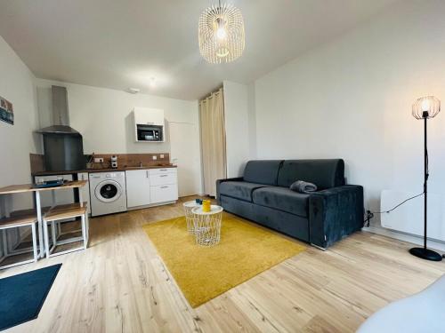 un salon avec un canapé et une cuisine dans l'établissement Casa Diderot - Studio, à Angers