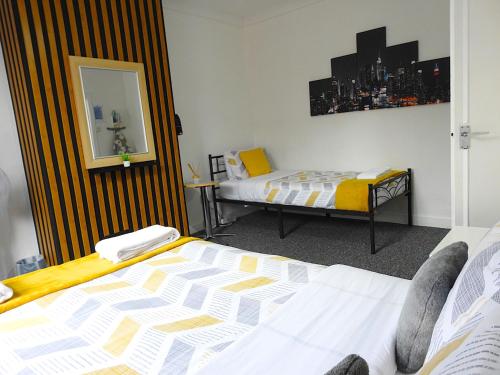 a hotel room with two beds and a mirror at Your Home away from Home!-Comfy-Cosy in Headingley