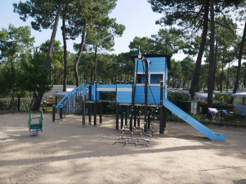 une aire de jeux avec un toboggan bleu dans un parc dans l'établissement Bonne Anse Plage Mobile home 3 chambres 8 personnes, aux Mathes