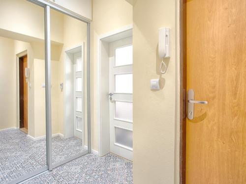 eine Glastür, die zu einem begehbaren Kleiderschrank führt in der Unterkunft Apartment Ondrejska 20 in Karlsbad