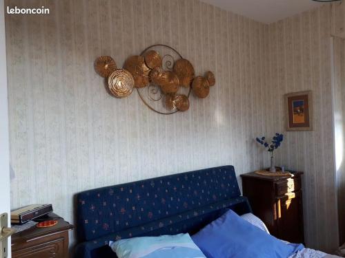 - une chambre avec un canapé bleu et un mur dans l'établissement appartement T3 tout confort, à Cabourg