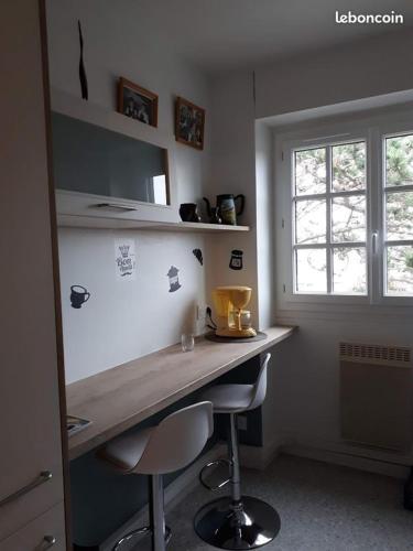 - une cuisine avec un comptoir et deux tabourets dans une pièce dans l'établissement appartement T3 tout confort, à Cabourg