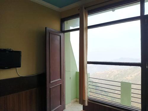 an empty room with a door and a window at Hotel D Pal in Kandāghāt