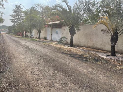 a dirt road with palm trees on the side of a house at Biomas Hotel in Brotas