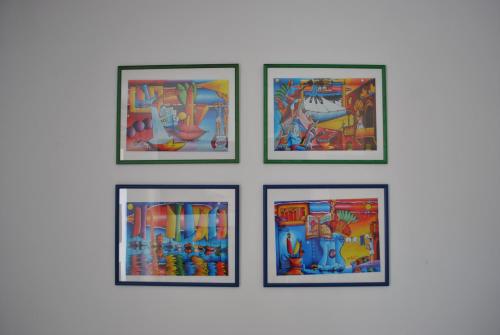 a group of four framed paintings on a wall at Lui in Makarska