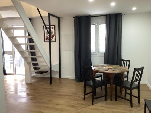 une salle à manger avec une table et des chaises et un escalier dans l'établissement Saleccia, à Santa-Lucia-di-Moriani