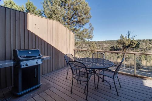 a table and chairs on a deck with a grill at Deschutes River View Eagle Crest in Redmond