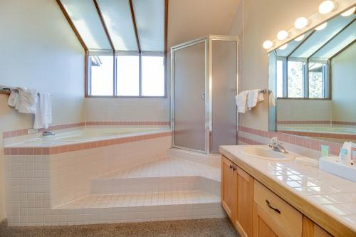 a bathroom with a shower and a tub and a sink at Deschutes River View Eagle Crest in Redmond