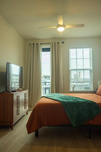 a bedroom with a bed and a flat screen tv at Two Story Penthouse, 2 Bedrooms with 2 and a half bathrooms, 2 Balconies, Skyline View, Pool in Richmond
