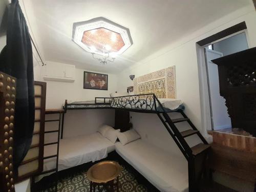 a room with two bunk beds and a couch at Dar Lalla Wafae in Fez