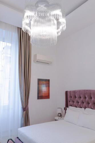 a bedroom with a bed and a chandelier at Domus Aurea Luxury Suites in Rome