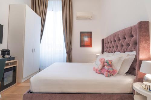 a bedroom with a bed with a teddy bear on it at Domus Aurea Luxury Suites in Rome