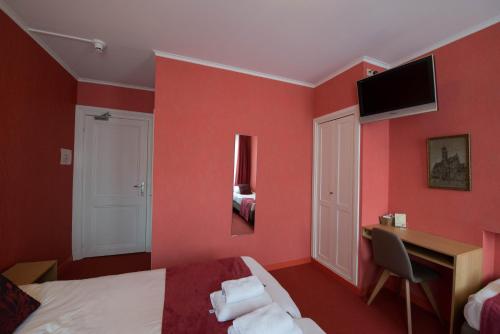 a bedroom with red walls and a bed and a desk at Hotel Groeninghe in Bruges