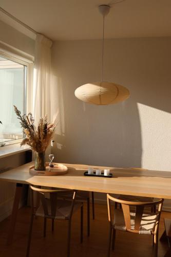 a dining room table with chairs and a pendant light at Cosy appartment near city, beach, metro & airport in Copenhagen