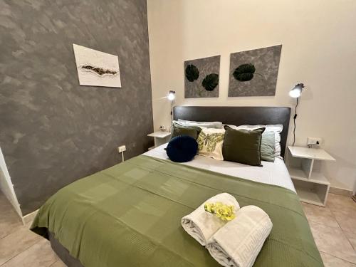une chambre avec un lit vert avec deux oreillers dans l'établissement Cuddly Apt, comodo per coppie e parcheggio, à Mestre