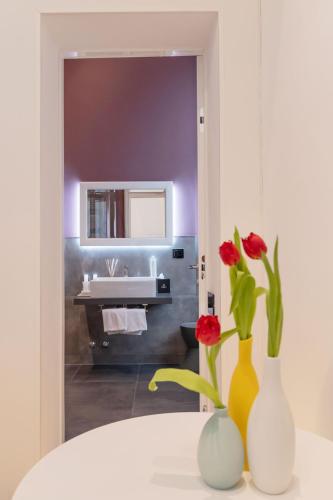 two vases with flowers on a table in a bathroom at Domus Aurea Luxury Suites in Rome
