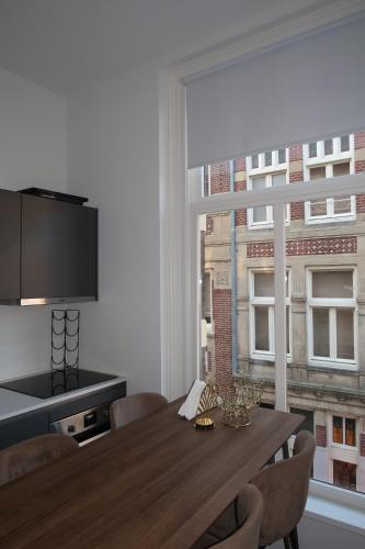 a dining room with a table and a large window at Appartement Rokin in Amsterdam