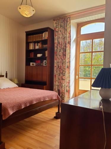 une chambre avec un lit, une fenêtre et un bureau dans l'établissement Gîte de Louis - Terrasse - Centre de Domme, à Domme