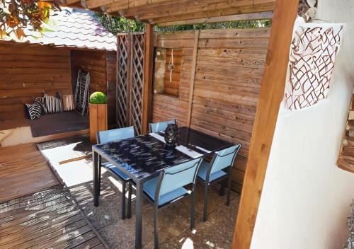 d'une terrasse avec une table noire et des chaises bleues. dans l'établissement Le CHAI MALICIEUX, à La Tremblade