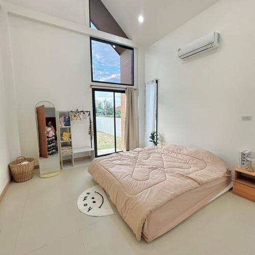 a bedroom with a bed and a large window at Prangsirihome guesthouseได้ทั้งหลัง in Lampang