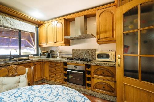 a kitchen with wooden cabinets and a microwave at Casa Centrtrica Umbrete in Umbrete