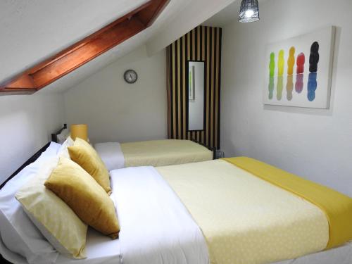 a bedroom with two beds and a painting on the wall at Be our Guest! Stylish-Central location-Comfy-Cosy in Headingley