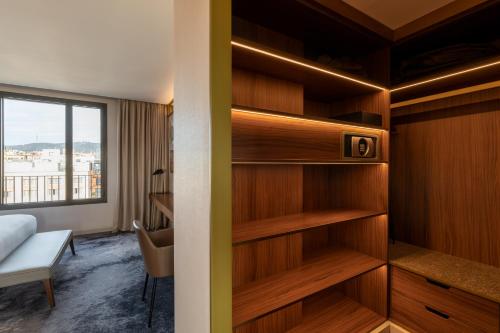 a room with wooden shelves and a bed and a window at Almanac Barcelona in Barcelona