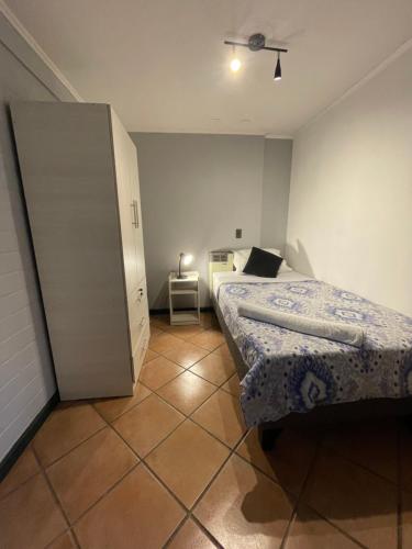a small bedroom with two beds and a cabinet at Hostal Brisa Serena in Santiago