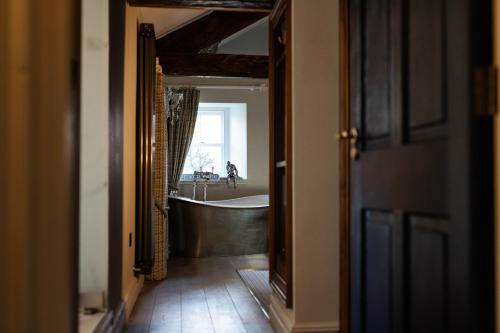 a bathroom with a bath tub and a sink at Aynsome Manor in Cartmel