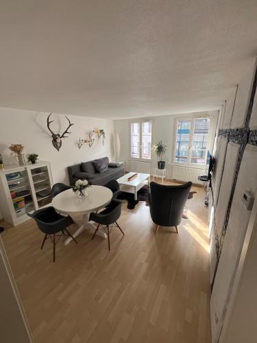 un salon avec un canapé, une table et des chaises dans l'établissement Nid Douillet au coeur du centre historique, à Colmar