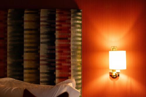 a lamp on a wall next to a curtain at Aynsome Manor in Cartmel